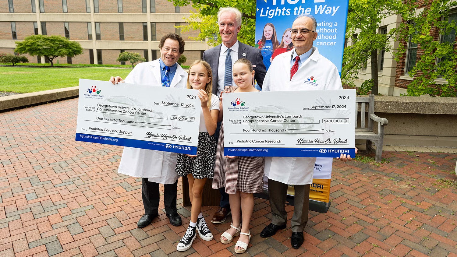 Representatives from Hyundai Hope On Wheels and Hyundai Motor America visited Georgetown University's Lombardi Comprehensive Cancer Center on Sept. 17 to present Jeffrey Toretsky, MD, (pictured left) with the inaugural Endowed Chair for Pediatric Oncology Grant and Hyundai Impact Grant and Aykut Üren, MD, (pictured right) with a Hyundai Scholar Hope Grant. Also pictured are Kevin Reilly (B'91) (center), owner and president of Alexandria Hyundai and vice chair for Hyundai Hope On Wheels, and Emmy Cole (center left) and Raynie Clark (center right), Hyundai Hope on Wheels 2024 Youth Ambassadors.